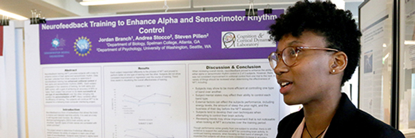 Photo of a woman standing next to her scientific poster